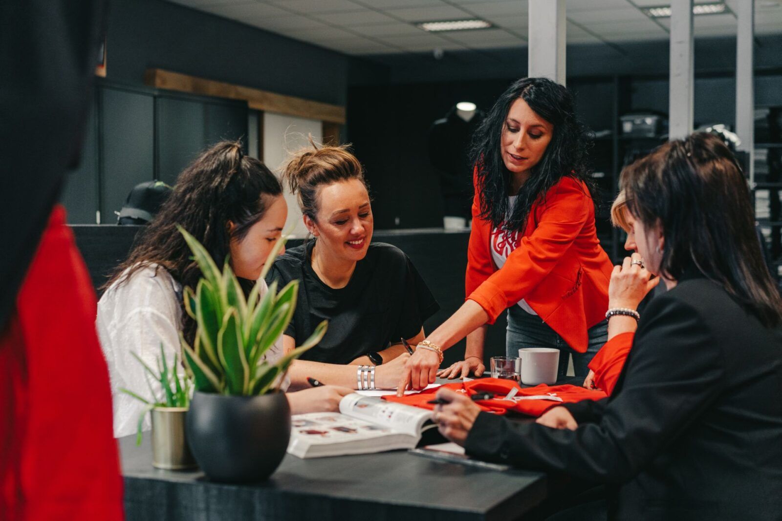 Team vergadert over textielbedrukking Limburg, bedrijfskledij Houthalen, en promotieartikelen bedrukken met logo op kleding.