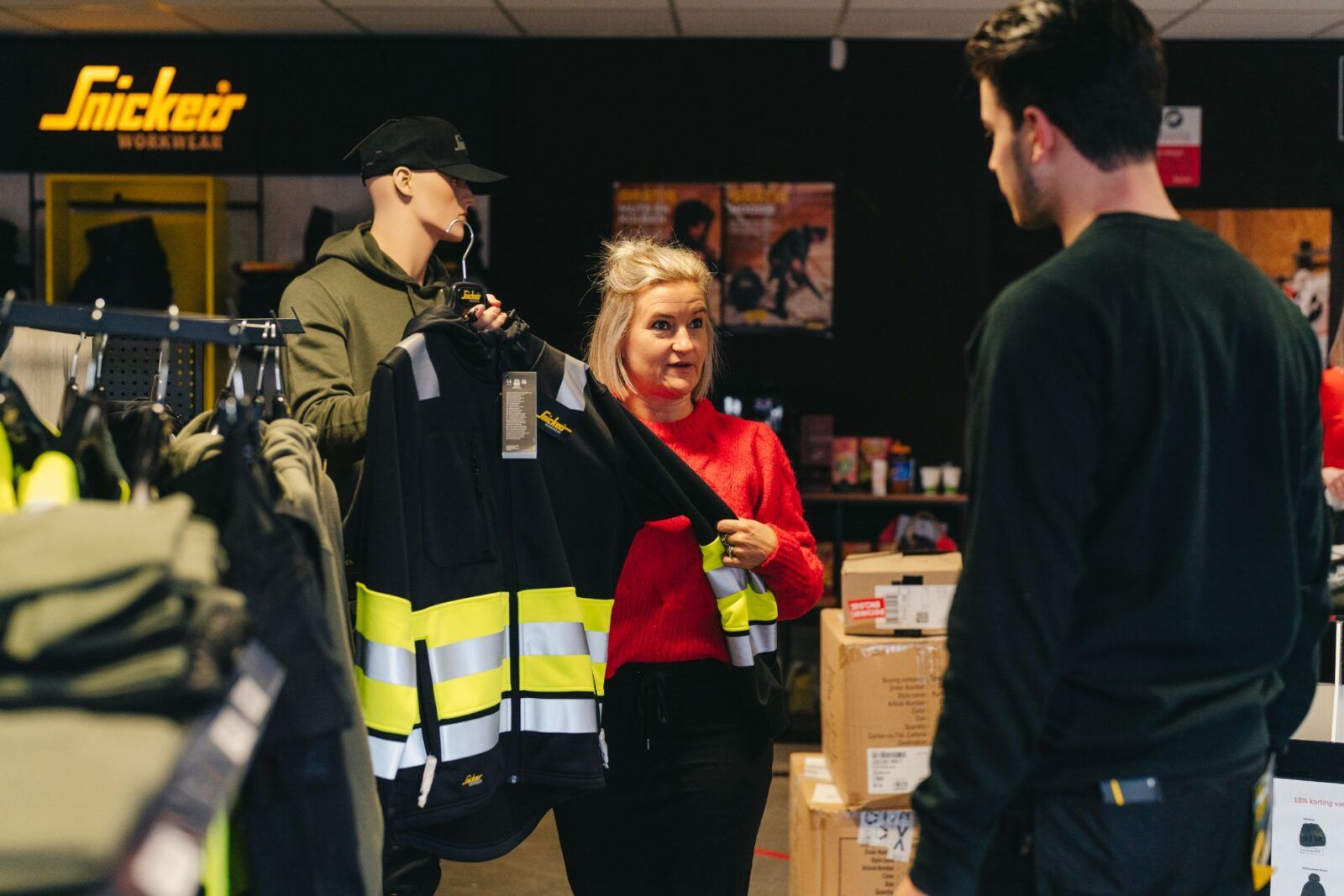 Medewerker Beerendruk stelt werkjas voor aan klant