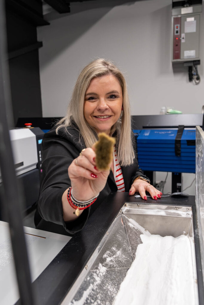 Vrolijke vrouw demonstreert nieuwe printer. Innovatieve technologie voor betere kwaliteit en nóg scherpere prijzen in professionele setting.