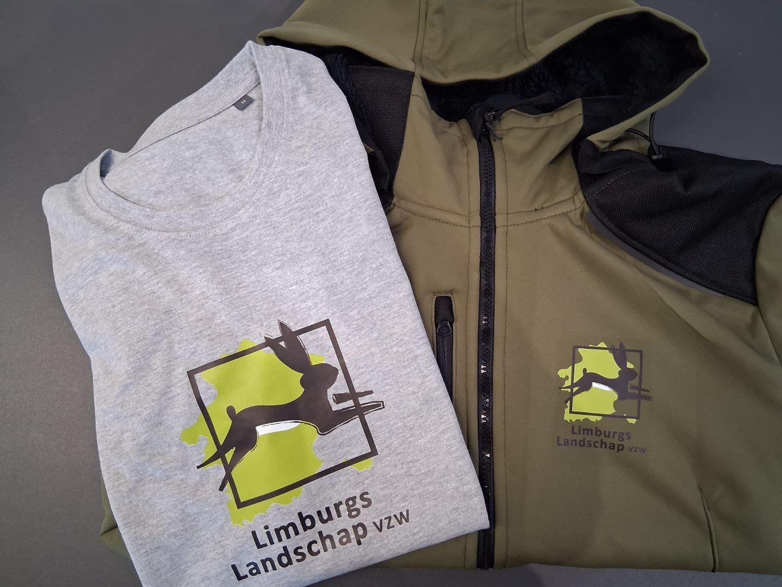 Limburgs Landschap bedrijfskleding met logo, grijs T-shirt en groene jas, representeren samenwerking met Limburgs Landschap: Bedrijfskleding met een Verhaal.