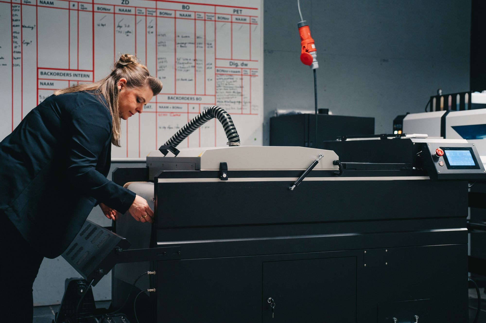 Vrouw werkt met nieuwe printer voor betere kwaliteit en scherpere prijzen, efficiëntie in een moderne kantooromgeving.